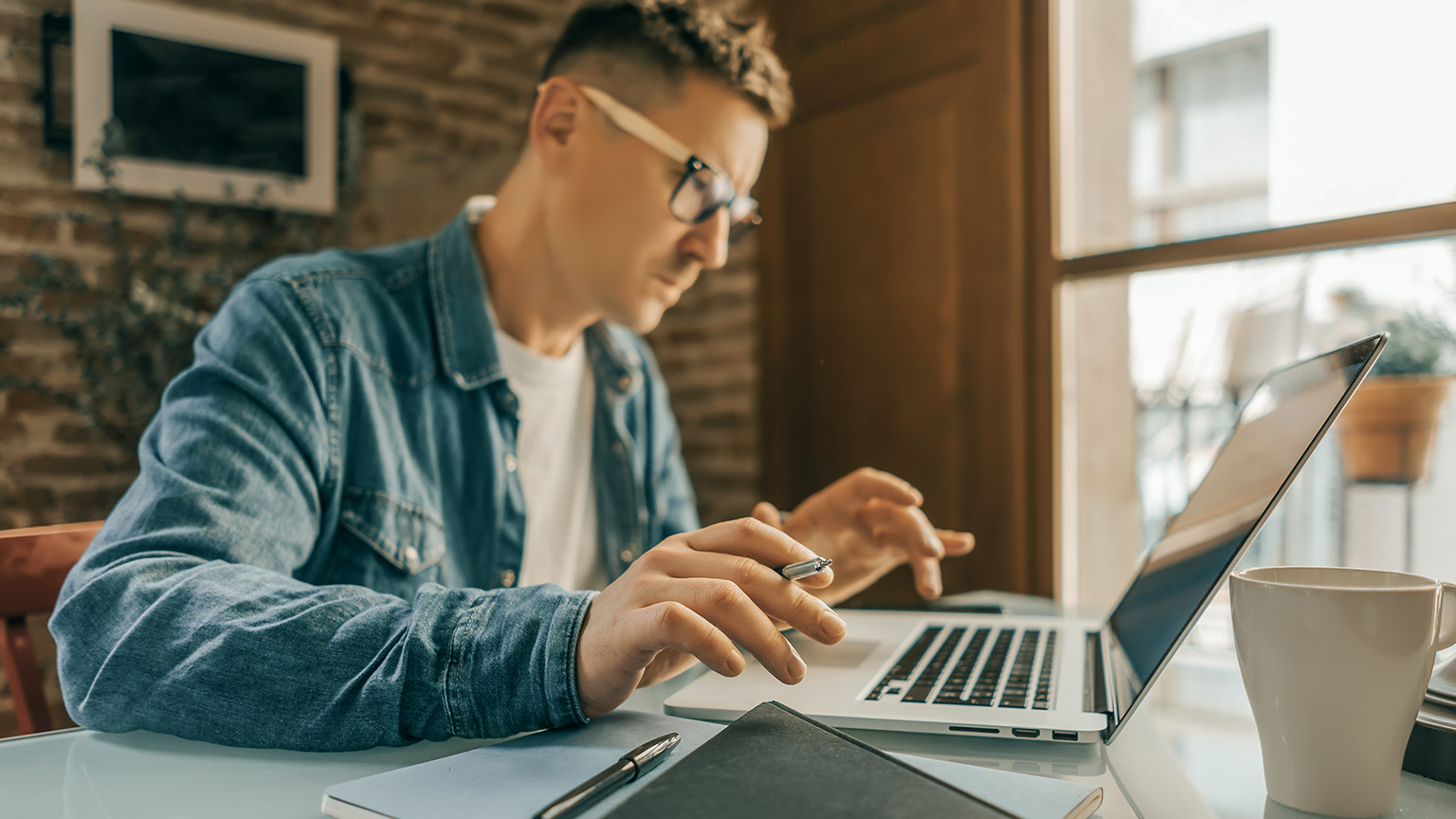 Close-up photo of male hands with laptop working remotely from home