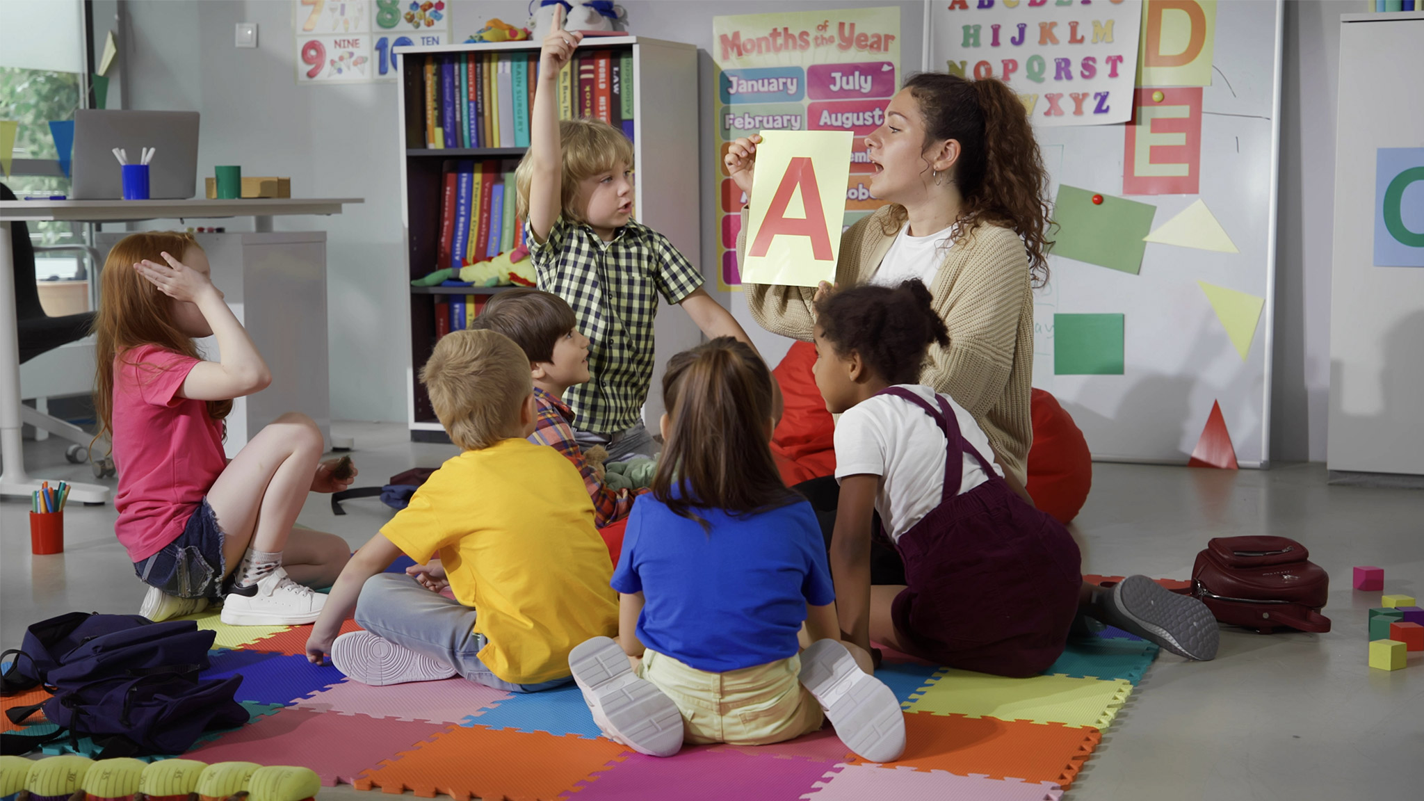 Female teacher hold flashcard with letter a teaching preschool kids alphabet.