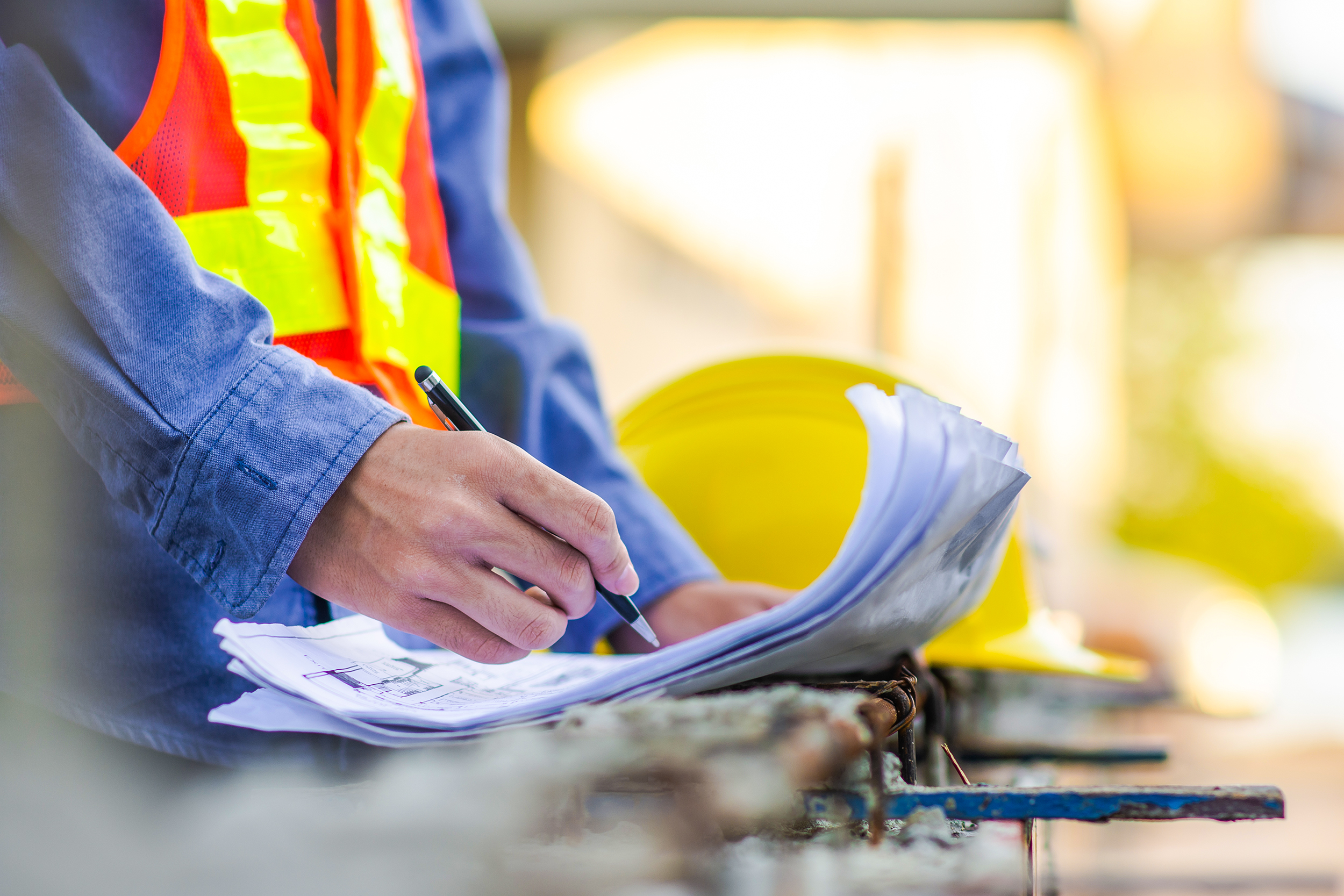 A foreman checking a list of items on a building site