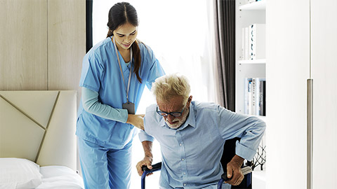 A nurse helping a man get up