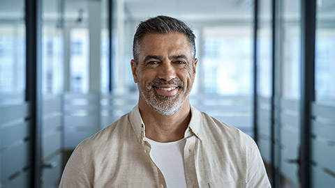 Headshot close up portrait of indian or latin confident mature good looking middle age leader, ceo male businessman on blur office background.