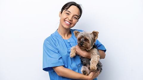 Young veterinarian woman with dog isolated on white background with happy expression