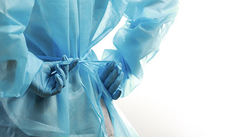 Rear view of a medical worker wearing a protective medical suit to protect against coronavirus