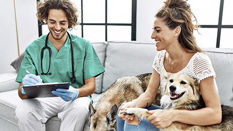 Veterinarian checking the record with client infront of him