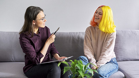 Teen girl giving interview to social worker. School psychologist talking with student