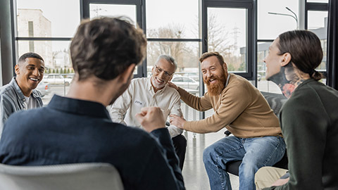 Cheerful interracial group of people talking to a therapist in office