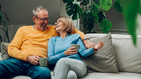 Portrait of a happy elderly couple hugging and relaxing together on the sofa