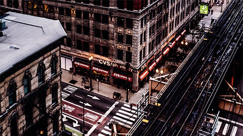 A large CVS Pharmacy nestled at the bottom of building in a quiet metropolis