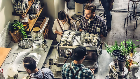 A couple purchasing their morning coffee from a local, trendy cafe