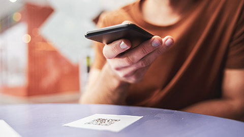 A shallow DOF view of a person checking in with a QR code