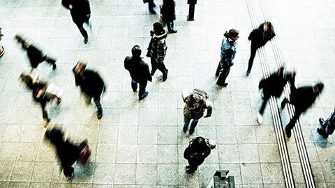 Commuters making their way through a train station at peak hour