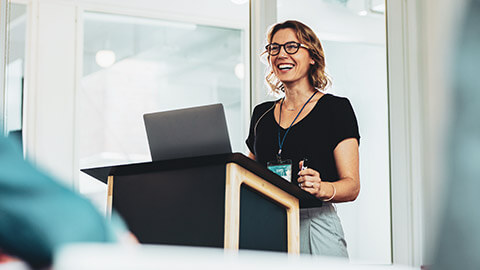 A business professional making a presentation to a room of colleagues