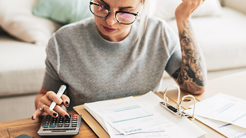 A young business owner doing financial calculations in her home office