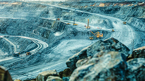 Earthmovers and and excavator in a large iron ore mine