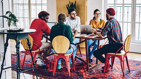 A team holding an animated meeting in their trendy office