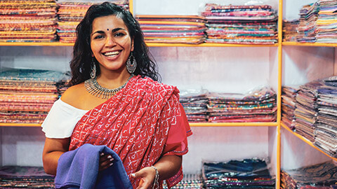 A smiling business owner in her sari shop