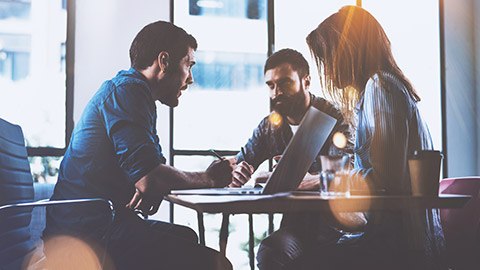 A serious conversation with 3 people around a table