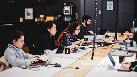 A number of employees working in an open plan office