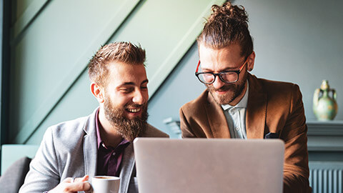 A pair of marketing executives discussing information on a laptop