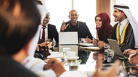 A mulitcultural group of business people discussing work at a boardroom table