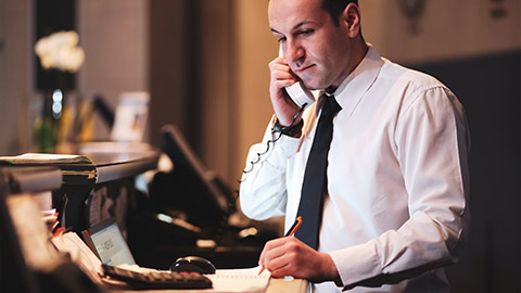 A duty manager checking the reservation system for a booking