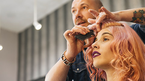 A hairdresser talking to a client while cutting their hair