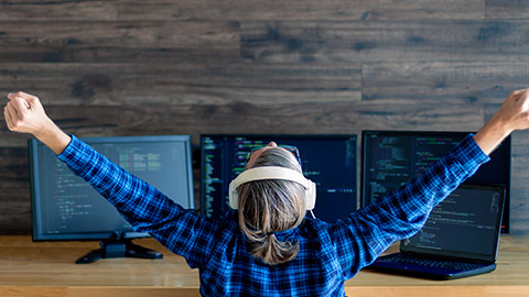 Back view of man freelancer in white headphones is working at home office