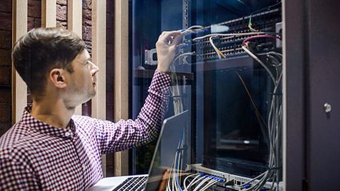 In the server room a technician/ It engineer/ connecting the internet network cable