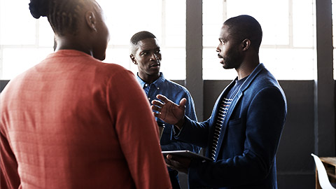 A person talking to colleagues standing up