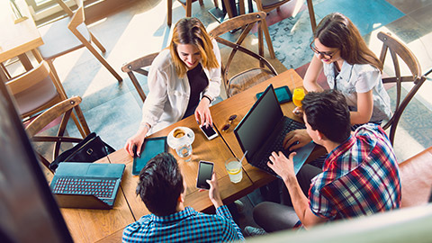 Group of young people sitting at a cafe, talking and enjoying, top view