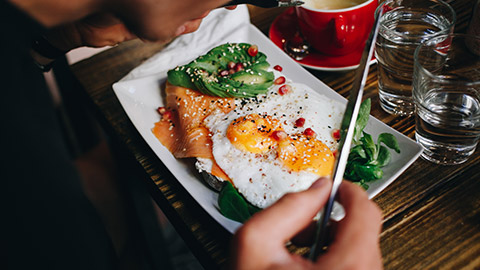 A close view of a person eating a plate of keto food