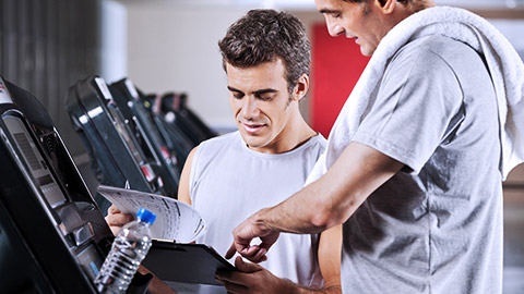 Gym instructor giving instruction for member's documents