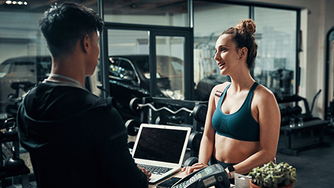 A client talking to a trainer in a gym