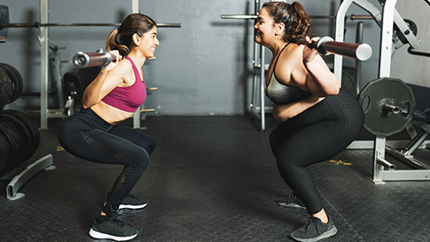 A trainer and client working out in a gym