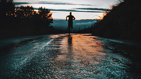 A person running outdoors at sunset