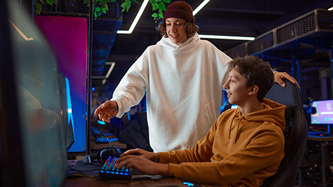 Two gamers talking at the monitor in gaming club