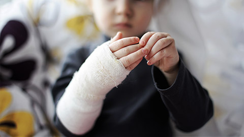 Little baby girl showing her bandaged hand