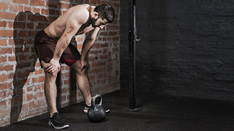 Athlete is leaning against the wall at the gym suffering breakdown to overcome