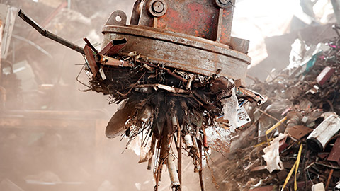 A large magnet being used in a junkyard