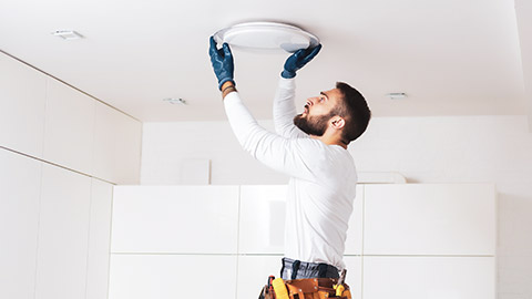 An electrician installing a light