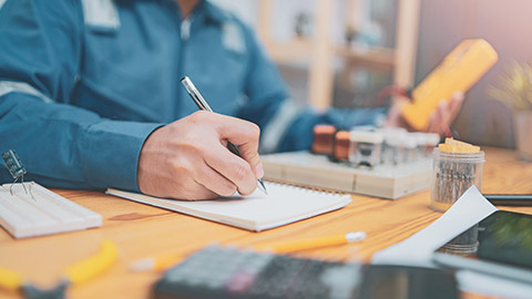 An electrician writing down figures