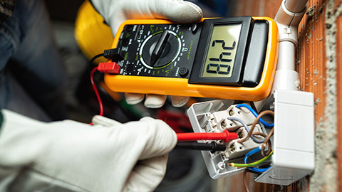 An electrician using a multimeter