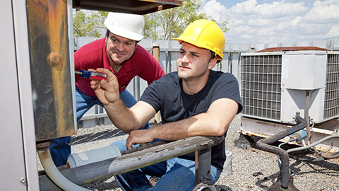 repair apprentice fixes an industrial compressor unit