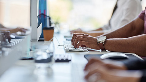 People typing on keyboards in an office