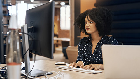 A person typing on a keyboard in a modern office