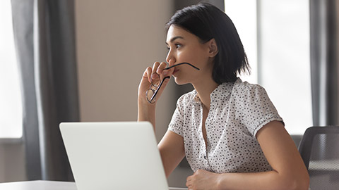 A person sitting at a desk thinking about solutions to a problem