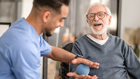 Patient having his hand massaged with a spiky massage ball