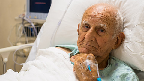 An elderly person in a hospital bed