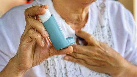 An elderly person with a ventolin inhaler