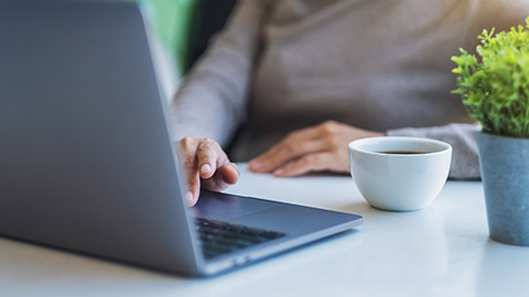 woman working and typing on laptop computer on the table in office